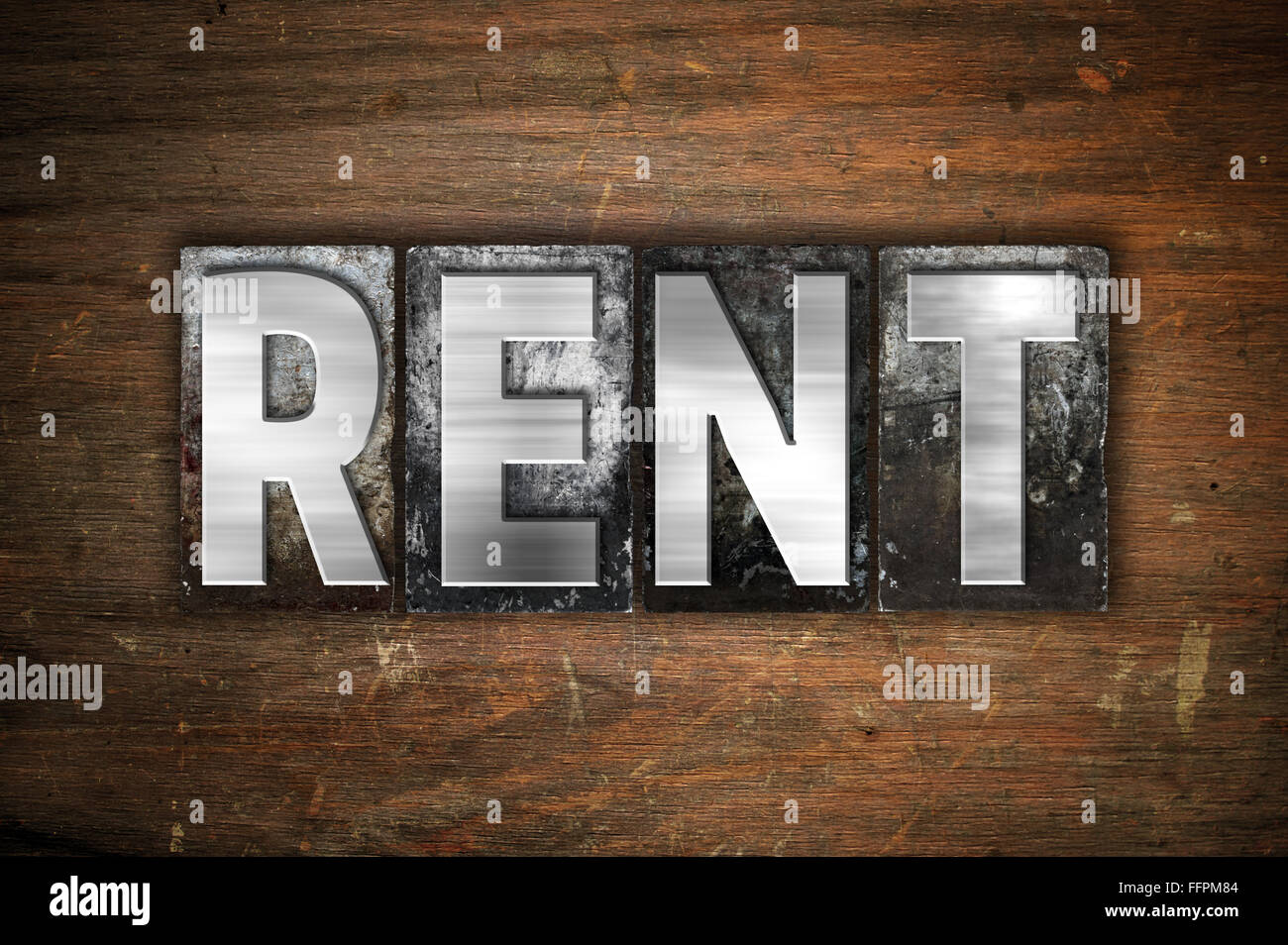 The word "Rent" written in vintage metal letterpress type on an aged