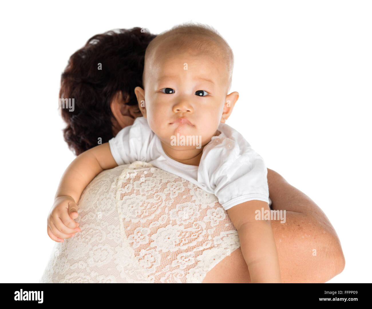 Grandmother burping grandson after meal. Isolated on white background. Stock Photo