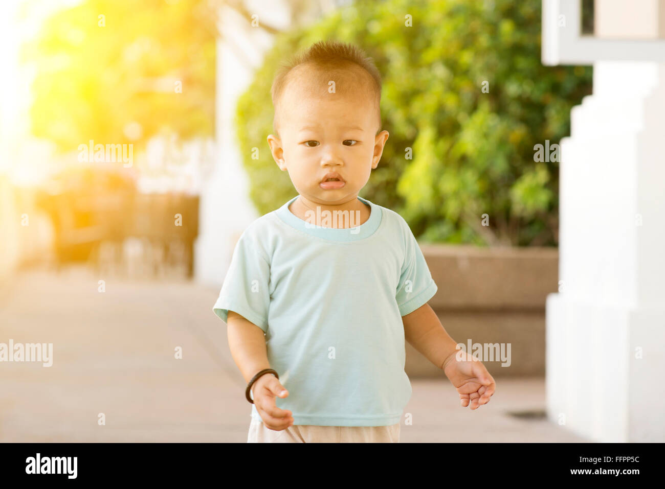 Portrait of Asian toddler walking outdoor in sunset. Stock Photo