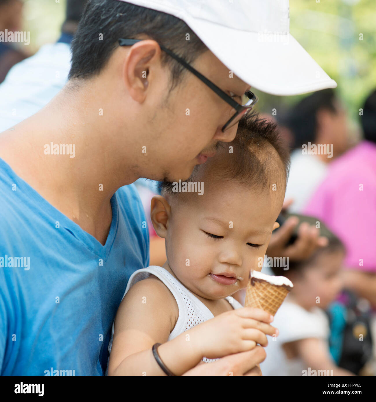 Father and child are eating ice creams on summer holidays. Candid family photo. Stock Photo