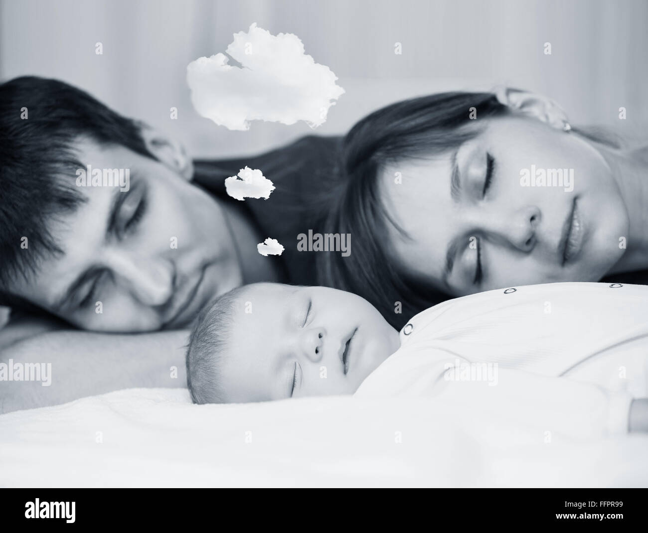 Beautiful baby sleeps  and dreaming with tired parents Stock Photo