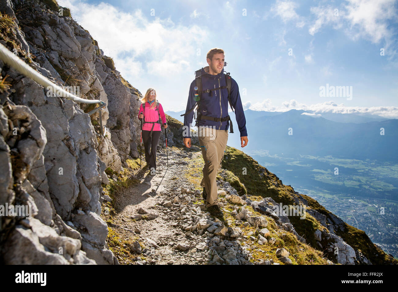 Hikers, man and woman hiking on a trail with safety rope Goetheweg, Karwendel, Innsbruck, Tyrol, Austria Stock Photo