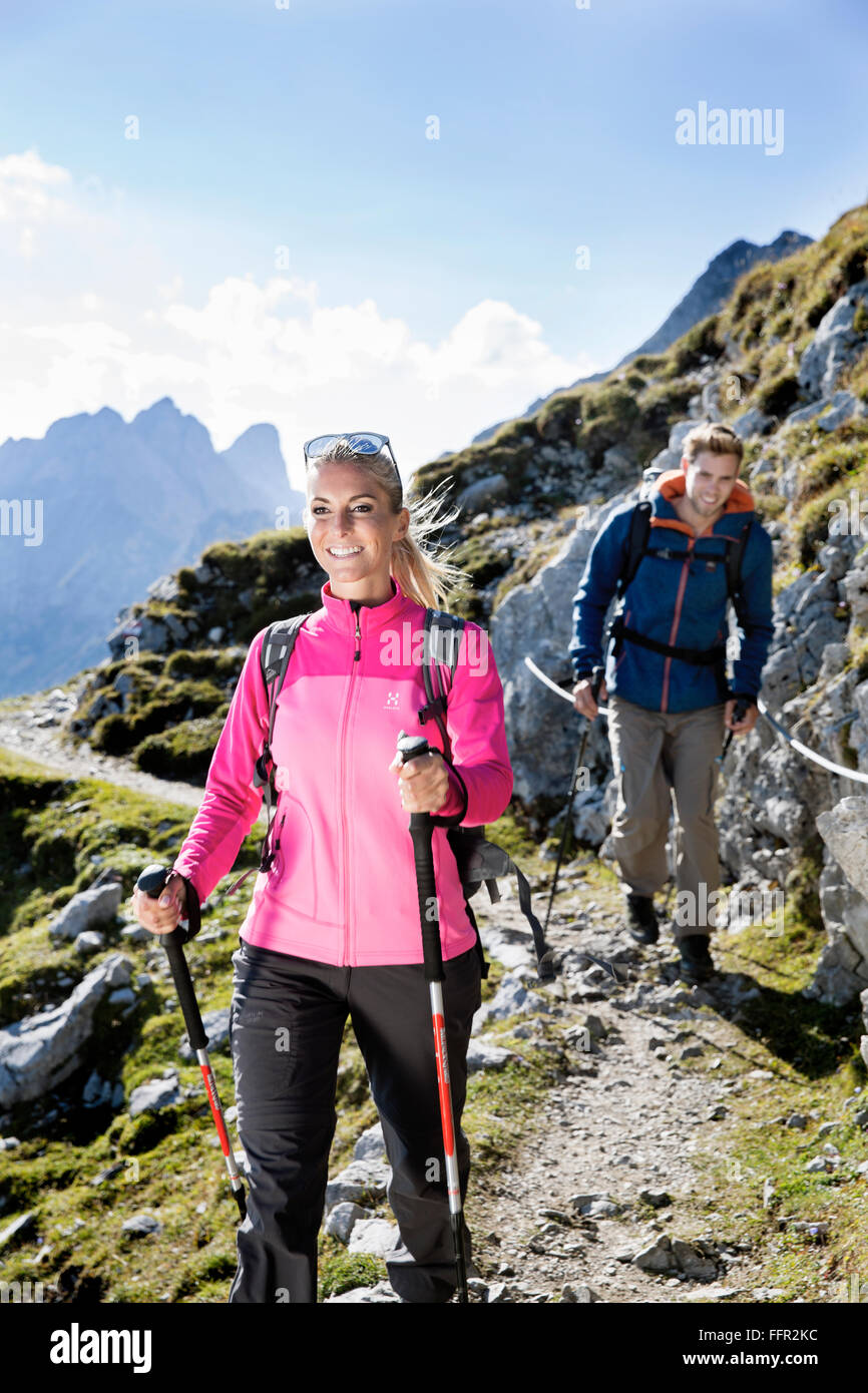 Hiker woman and man walking on a trail with safety rope Goetheweg, Karwendel, Innsbruck, Tyrol, Austria Stock Photo