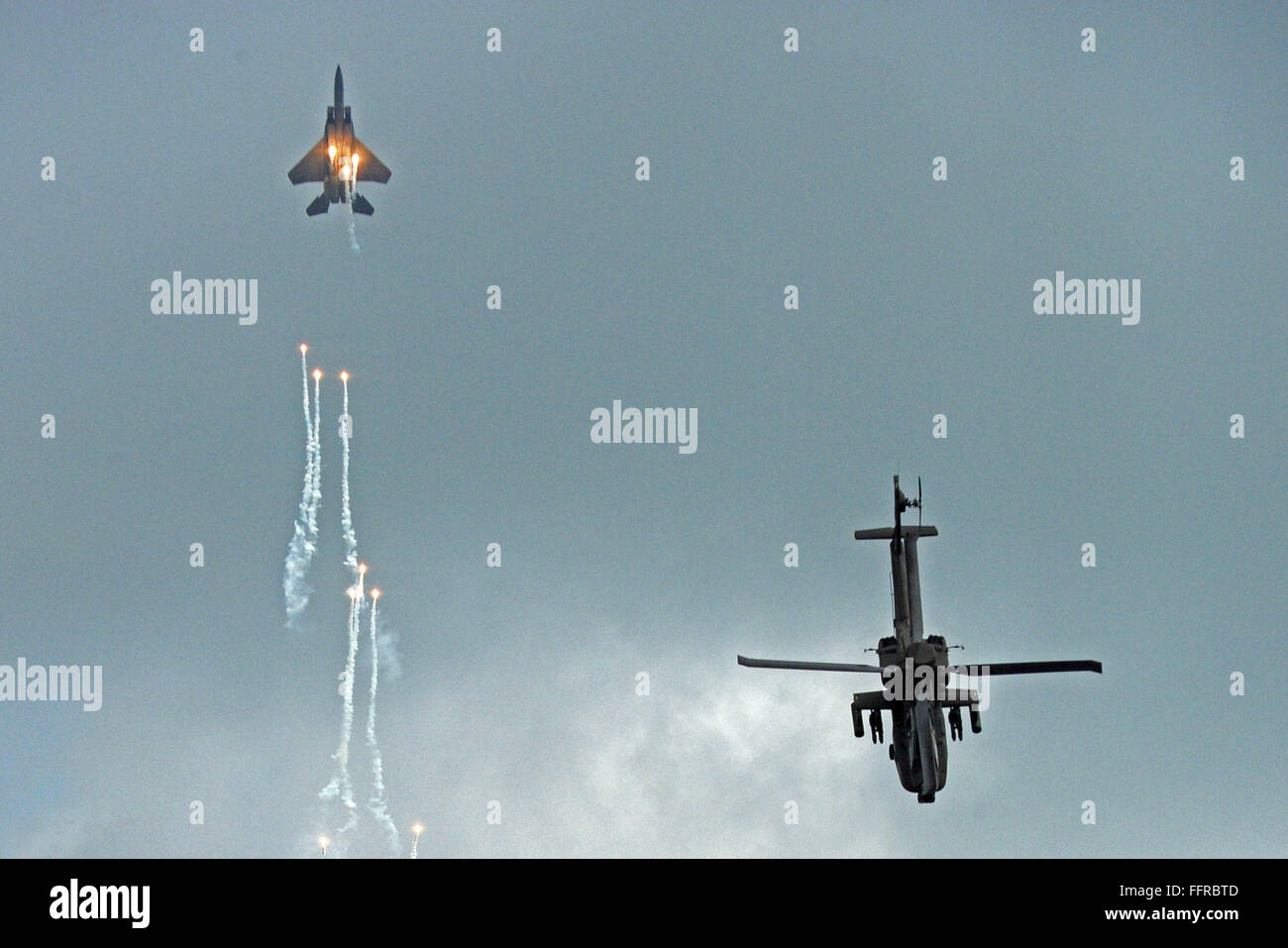 Singapore. 17th Feb, 2016. An F-15SG fighter aircraft (L) and an AH-64D Apache attack helicopter of the Singapore Air Force perform aerobatic flying during the Singapore Airshow held at Singapore's Changi Exhibition Centre, Feb. 17, 2016. The Singapore Airshow, Asia's largest and one of the most important aerospace and defence exhibitions in the world, kicked off Tuesday with a renewed focus on driving global aviation industry trends and developments. Credit:  Then Chih Wey/Xinhua/Alamy Live News Stock Photo