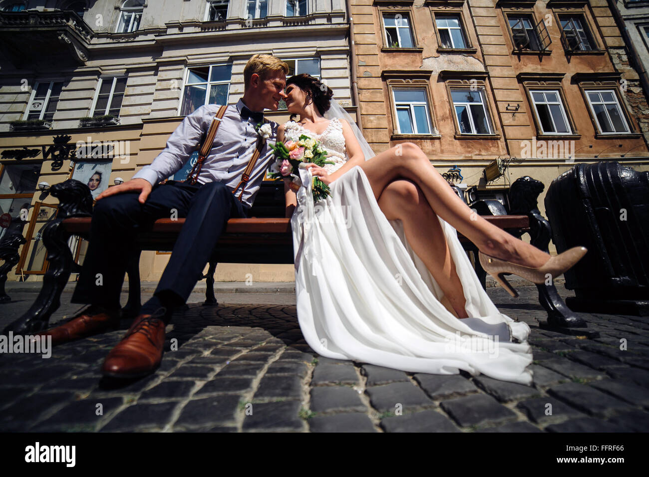 bride and groom sit on the bench Stock Photo - Alamy