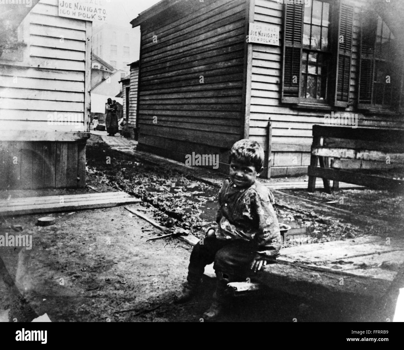 CHICAGO SLUMS. /nBoy seated on a sidewalk in a slum in Chicago