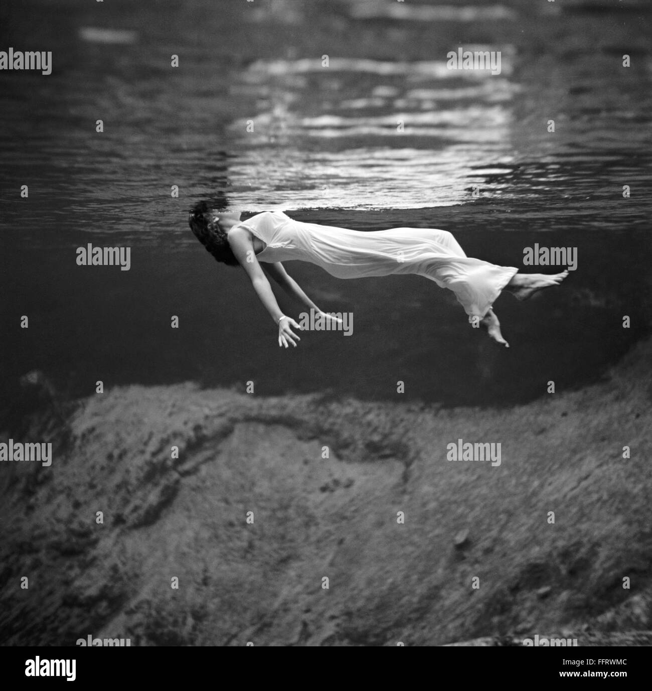 WOMAN FLOATING, 1947. /nA woman in a fancy dress floating underwater at ...