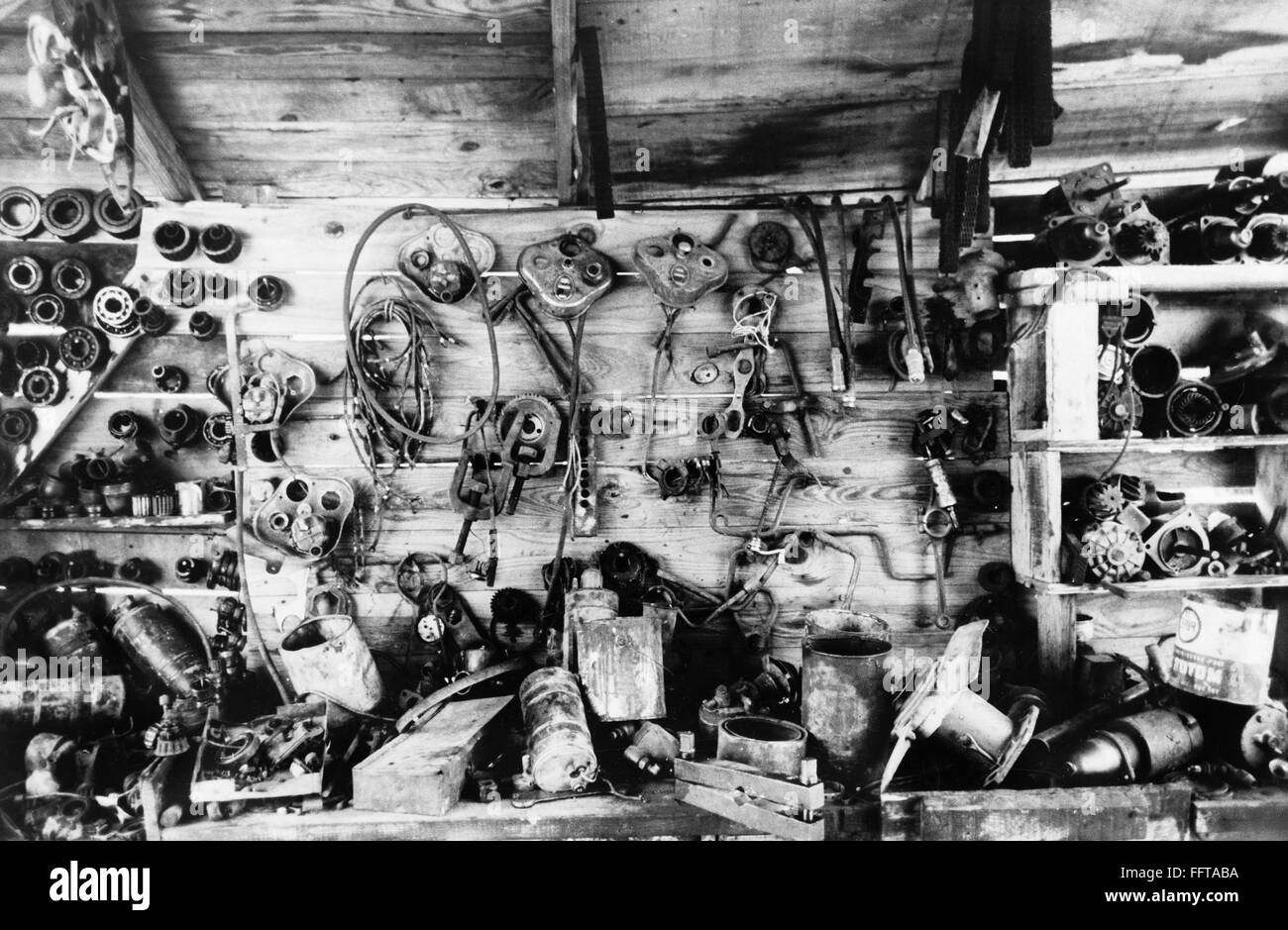 AUTO PARTS, 1938. /nAutomobile parts hanging on the wall of a junkyard