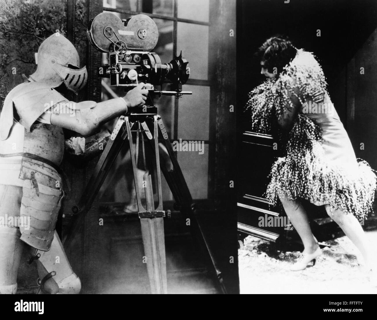 FILM: UNDERWORLD, 1927. /nFilming a scene for the gangster movie, directed by Joseph von Sternberg in 1927, the cameraman has armored himself against the blast as he films Evelyn Brent fleeing. Stock Photo
