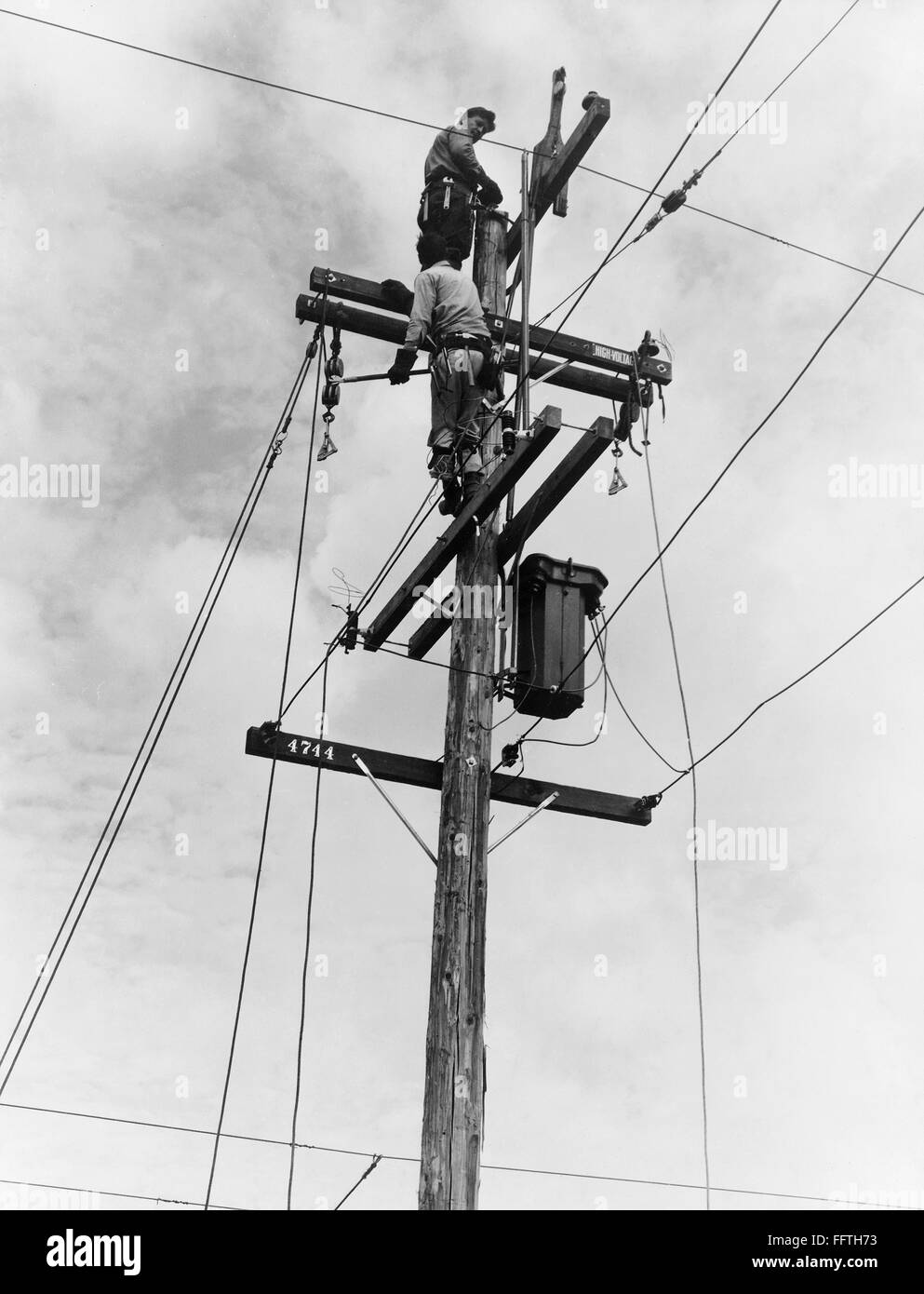 ELECTRIFICATION, 1938. /nWorkmen installing electricity on the top of utility poles in the San Joaquin Valley, California. Photograph by Dorothea Lange, November 1938. Stock Photo