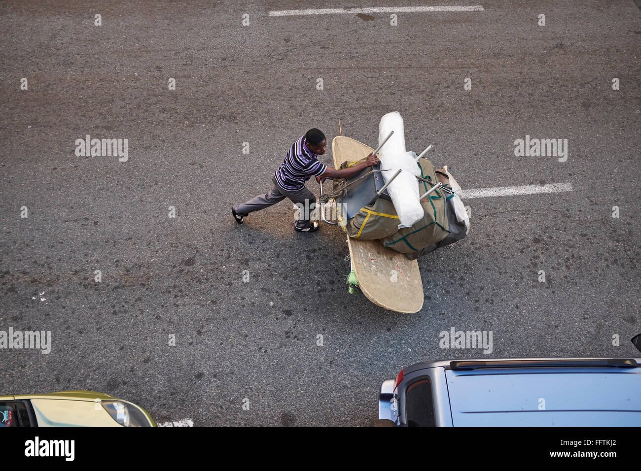 South Africans transports furniture on hand truck on a road in Cape