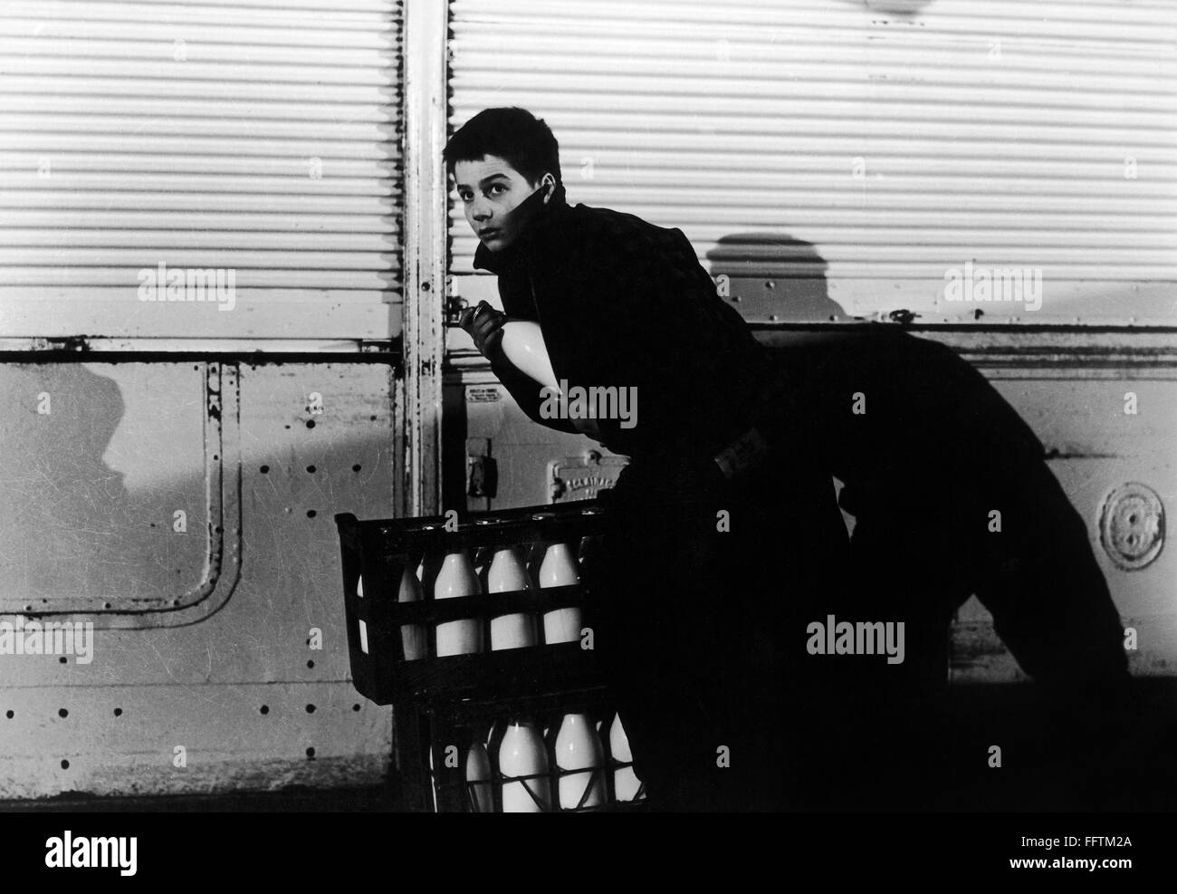 FILM: 400 BLOWS, 1959. /nJean-Pierre Leaud as the young Antoine Doinel stealing a bottle of milk in 'The 400 Blows' directed by Franτois Truffaut, 1959. Stock Photo