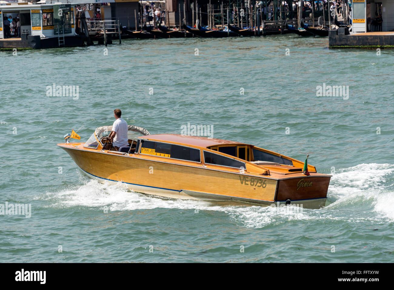 A Venetian water taxi, popular for private hire, on the Venetian Lagoon in Venice in northern Italy.  The original water taxi is built locally and Stock Photo