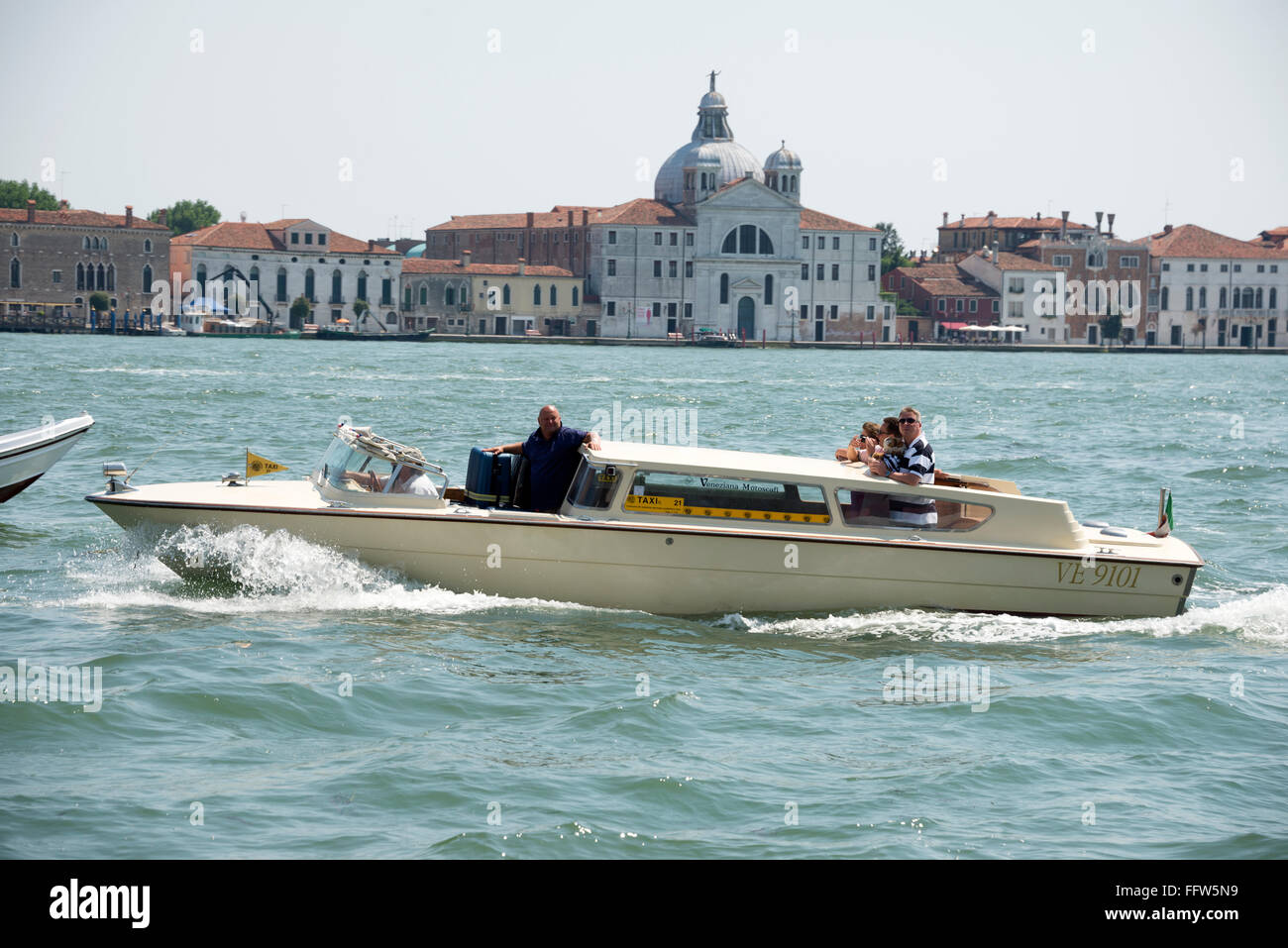 A Venetian water taxi, popular for private hire, on the Venetian Lagoon in Venice in northern Italy.  The original water taxi is built locally and Stock Photo