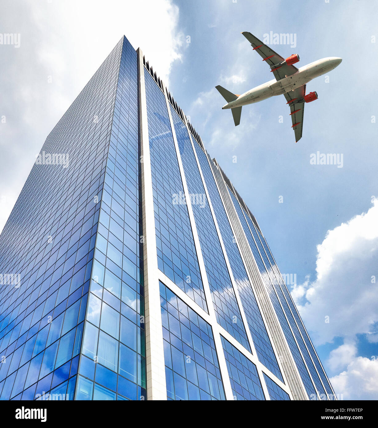 A jet plane flying low over Office building with plate glass walls and
