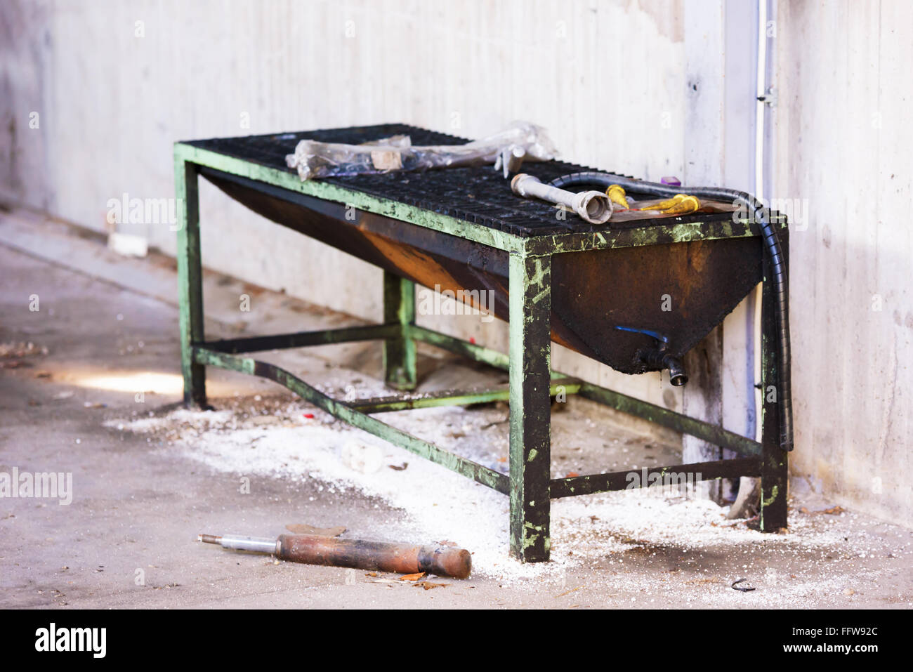 An abandoned industrial cleaning station with old tools scattered