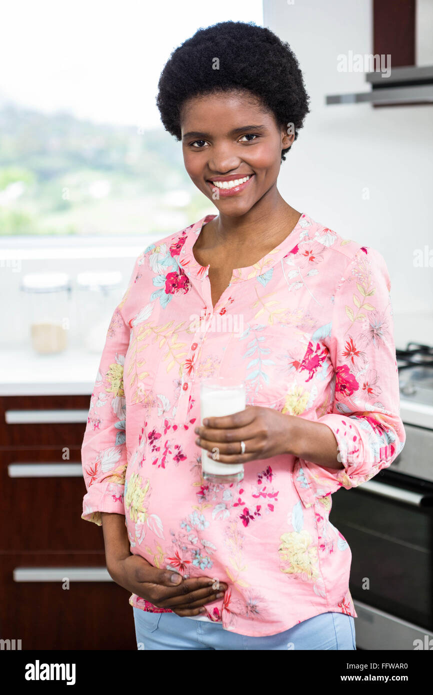 Pregnant woman drinking a glass of milk Stock Photo