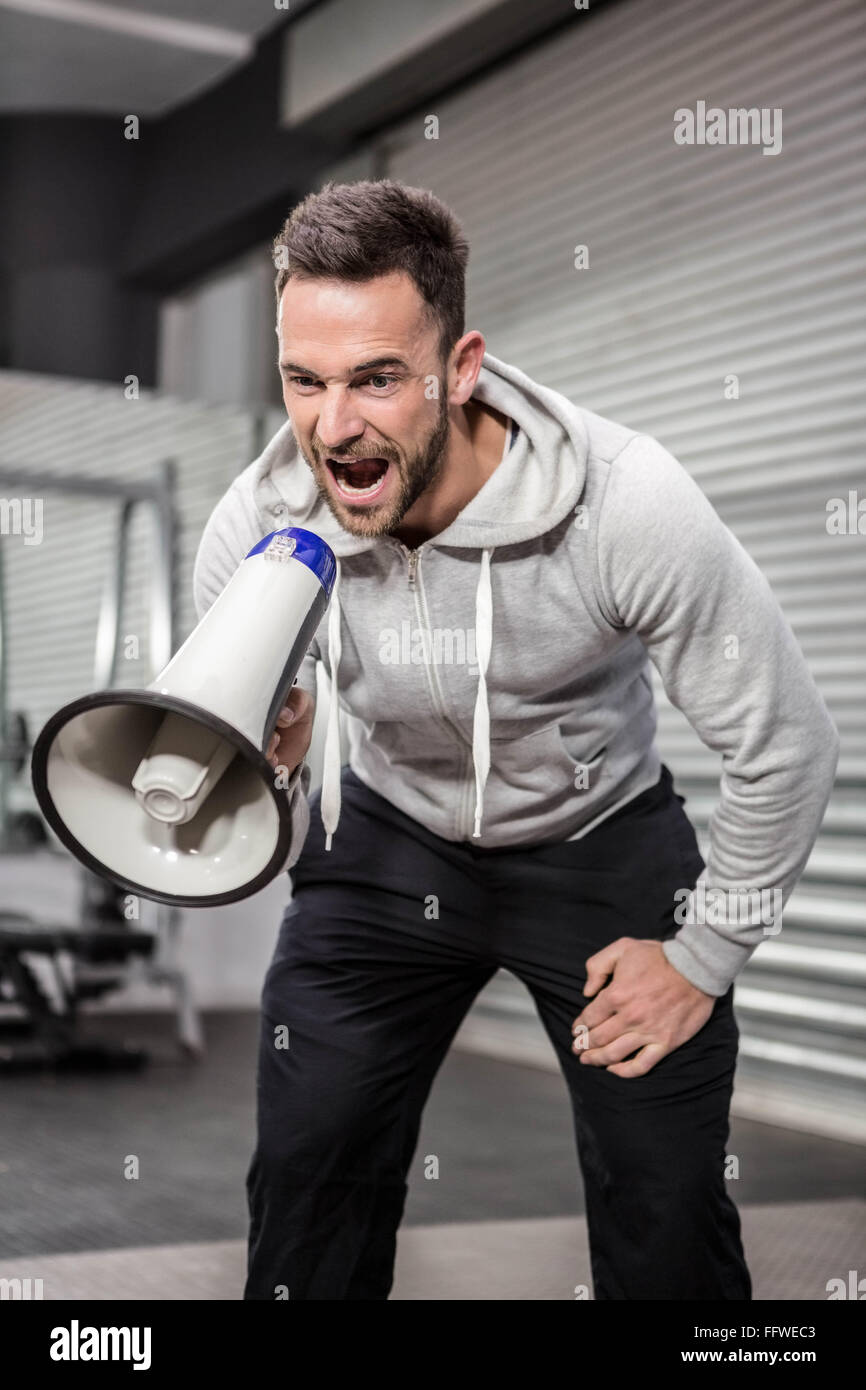 Muscular man shouting on megaphone Stock Photo - Alamy
