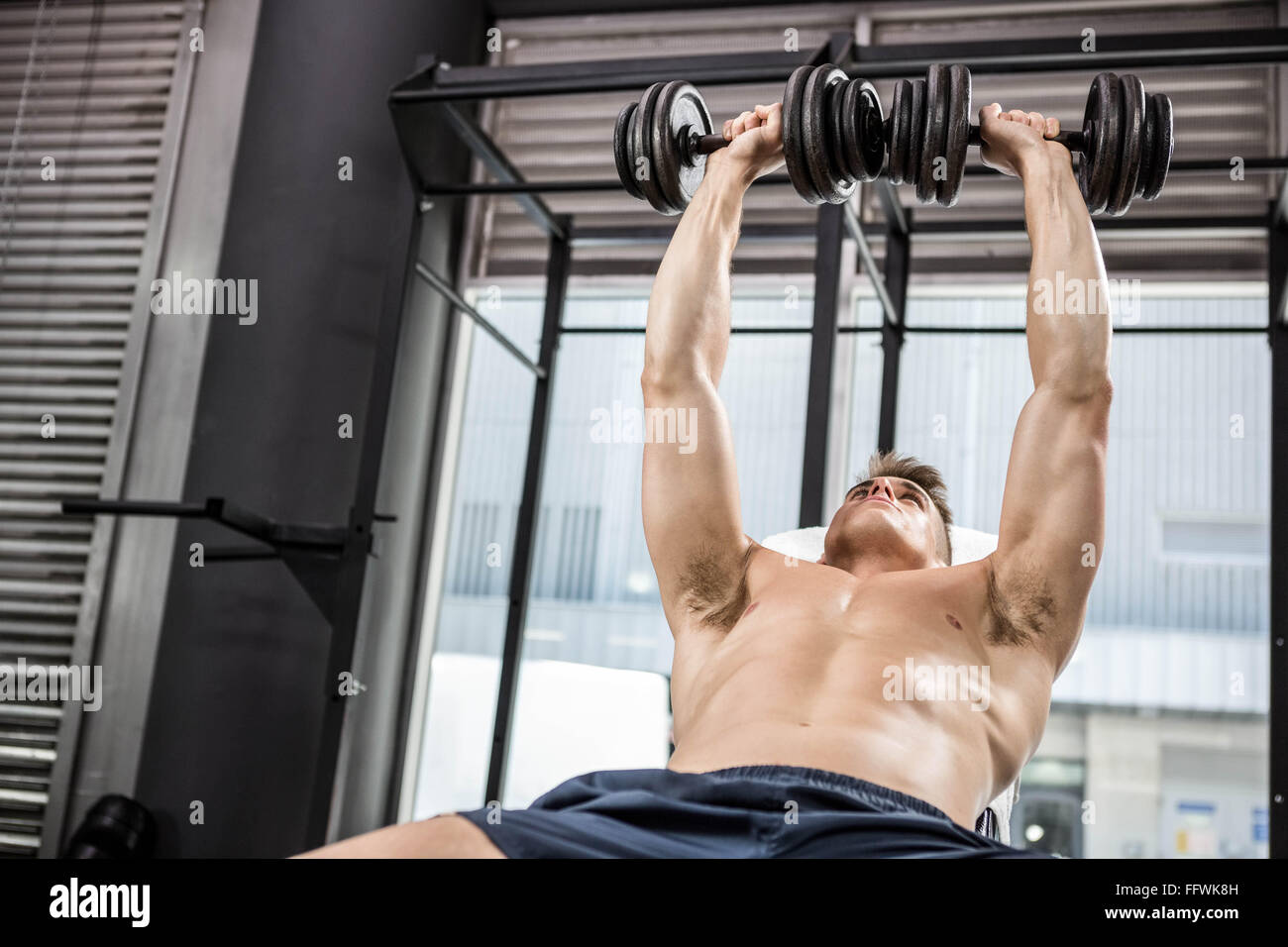 Shirtless man lifting heavy dumbbells on bench Stock Photo Alamy
