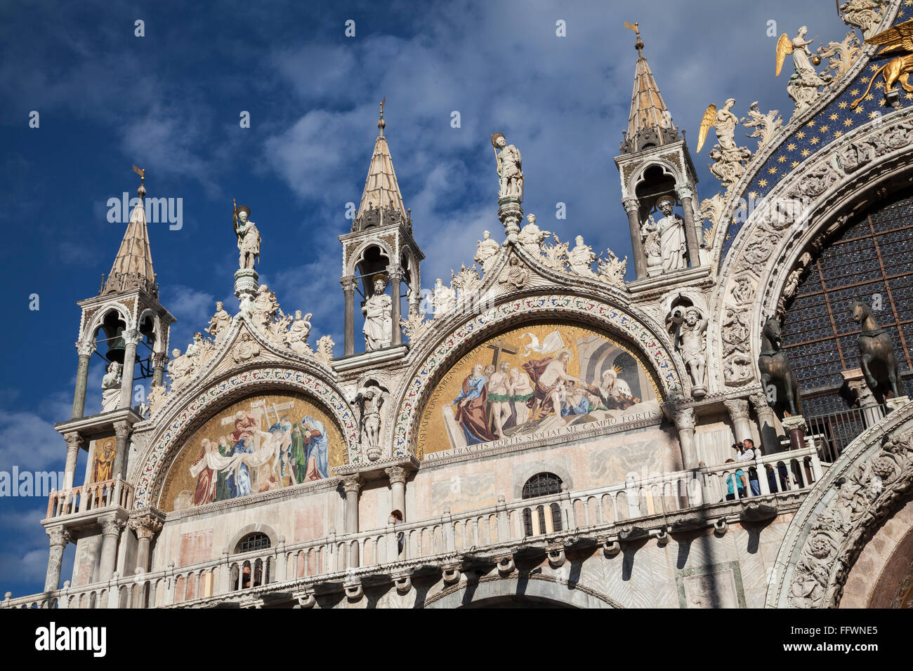 Sunlit view of the detailed upper edifice of St Marks Basilica in Venice, against a blue sky Stock Photo