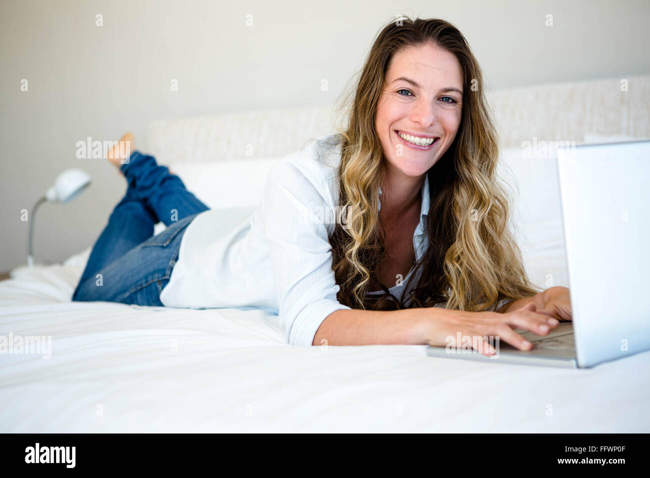woman lying on her bed on her laptop Stock Photo - Alamy