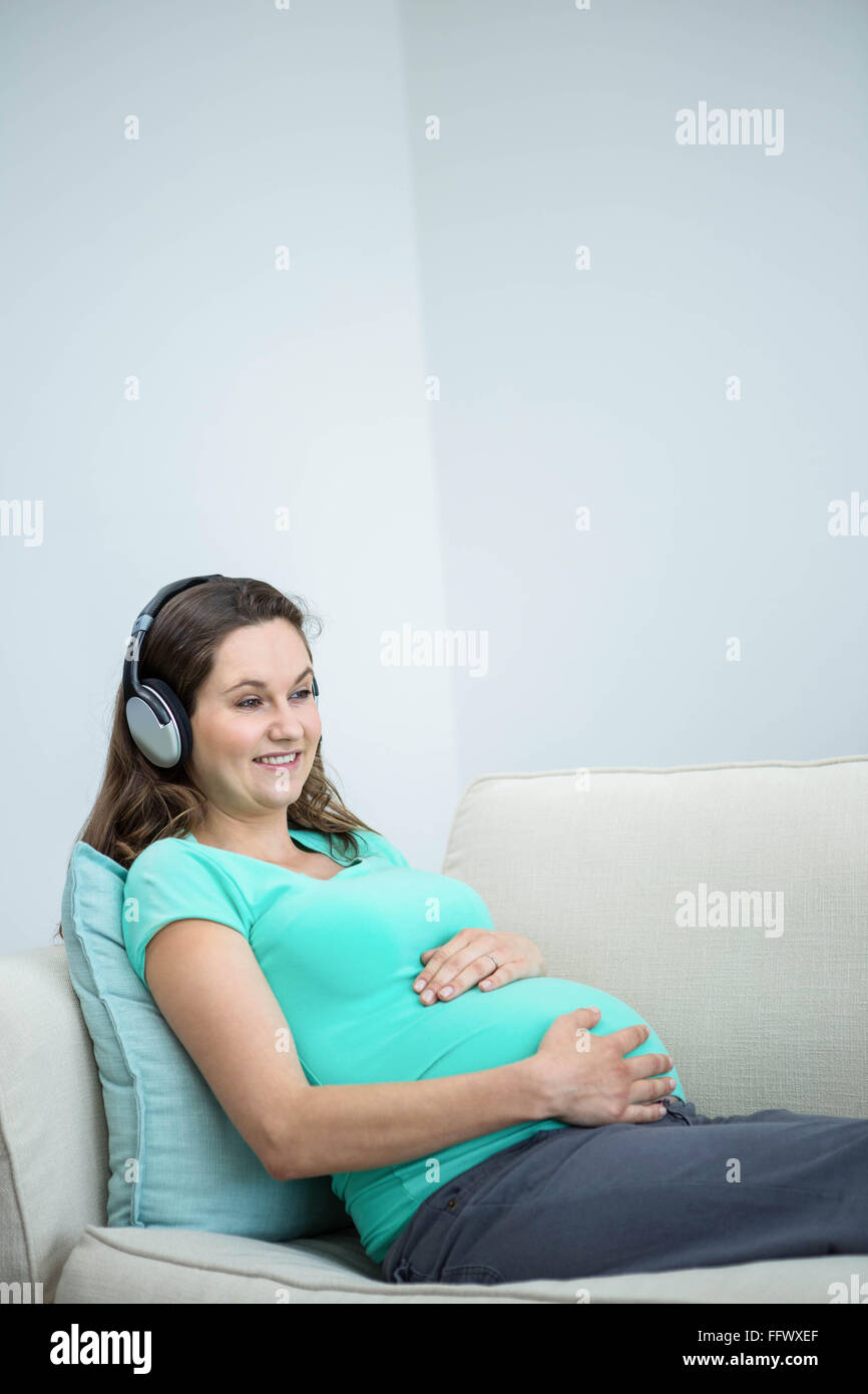 Pregnant woman listening to music Stock Photo - Alamy