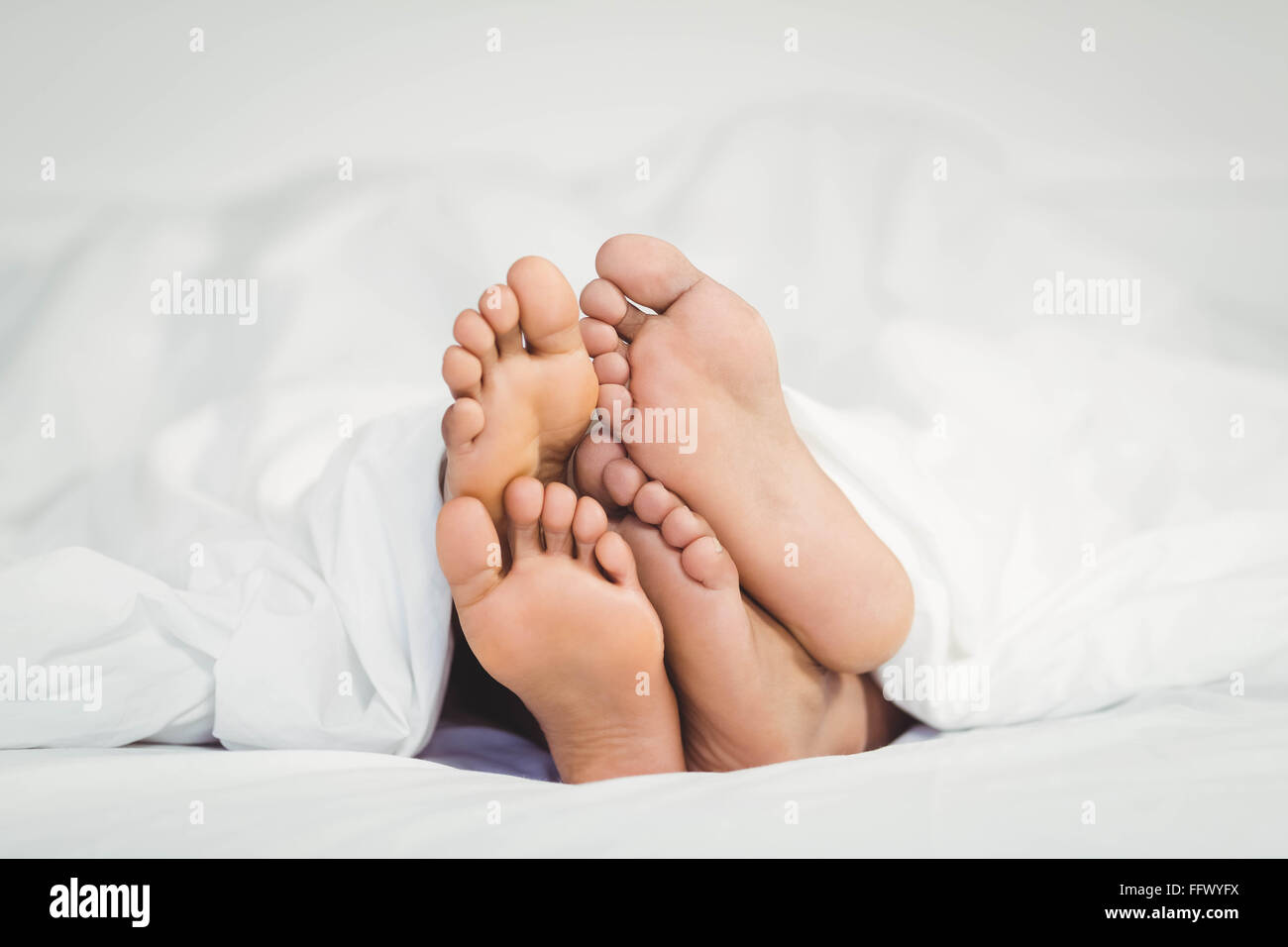 Feet sticking out from the blanket Stock Photo Alamy