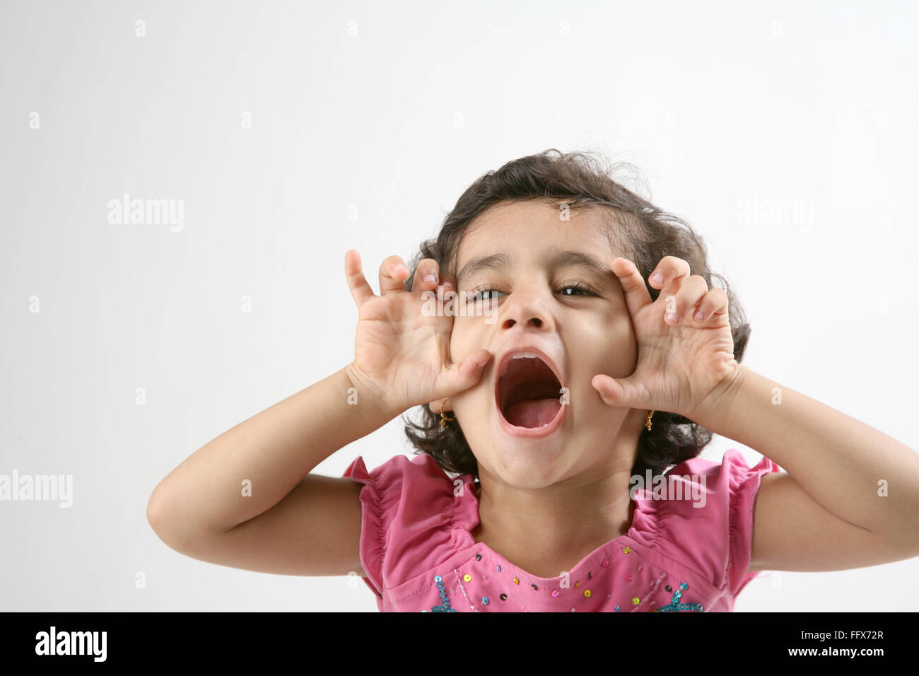 young girl of 4 years playful mood and trying scare others by making