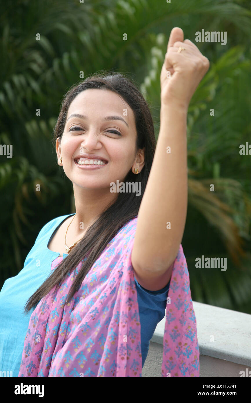 young lady lifting one hand with fist and expressing winning position
