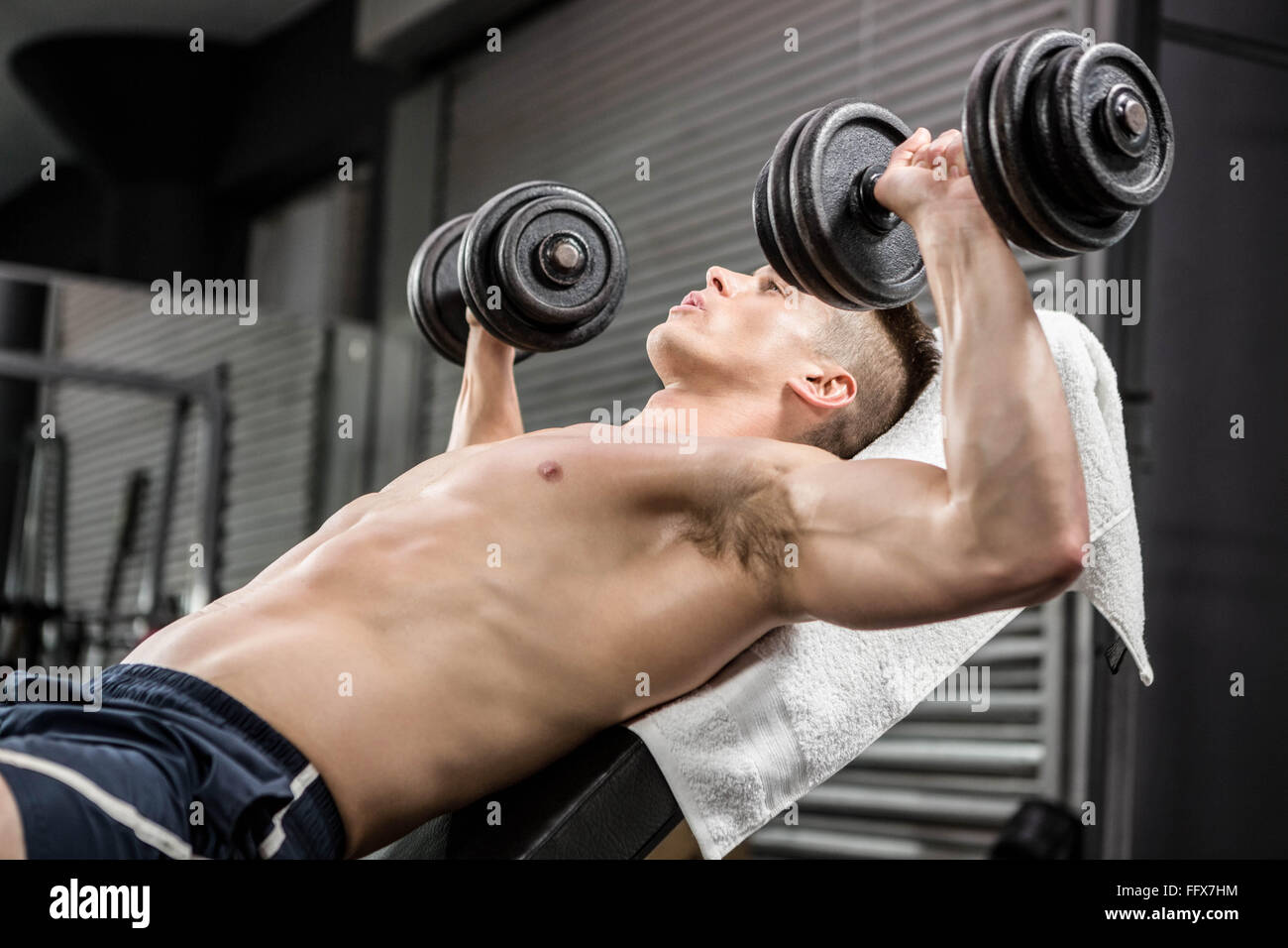 Shirtless man lifting heavy dumbbells on bench Stock Photo Alamy