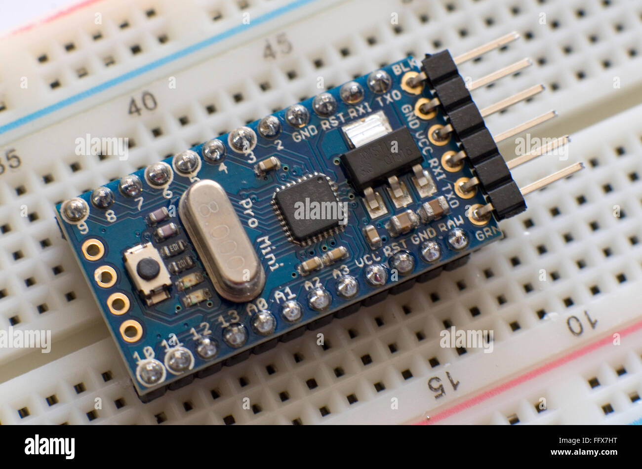 Arduino Pro Mini micro-controller plugged into a breadboard. Stock Photo