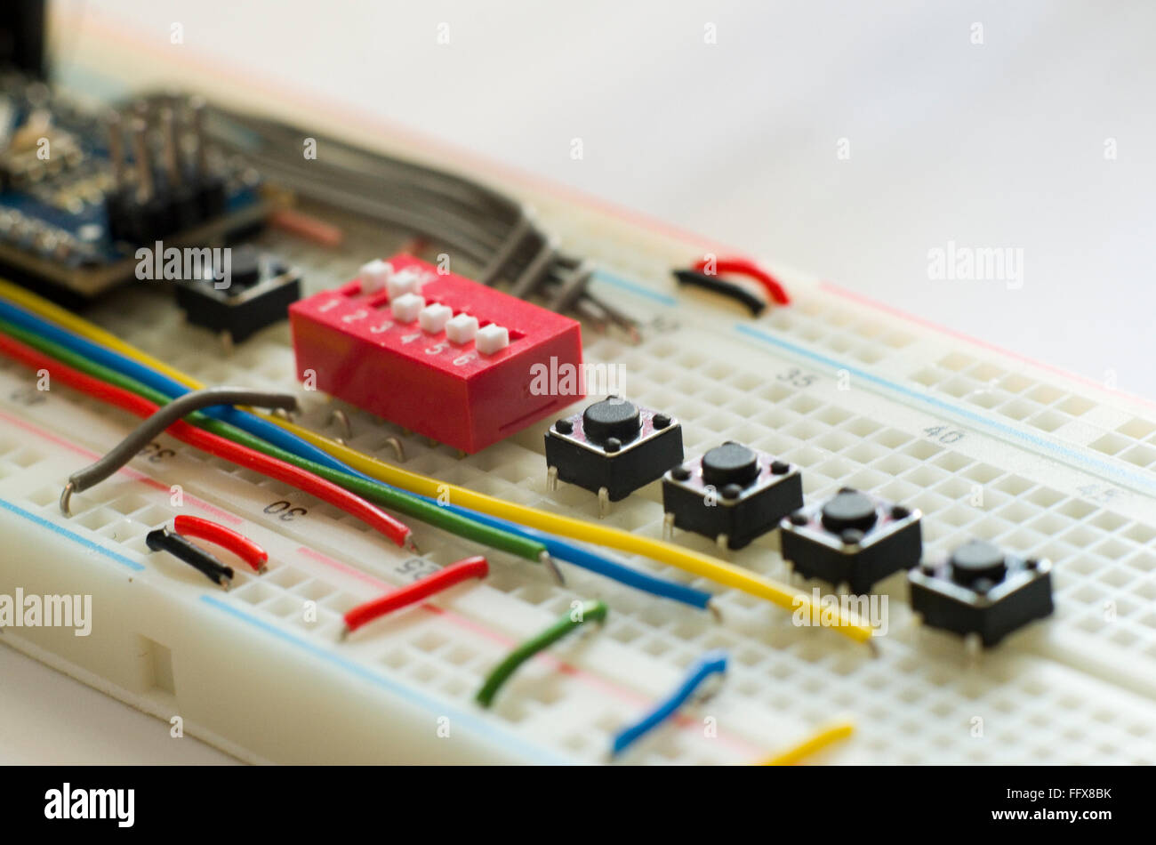 Electronics prototyping board (breadboard) with an assortment of switches and wires. Stock Photo