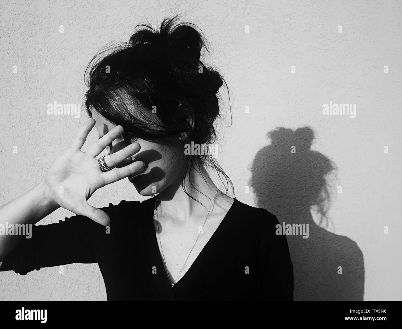 Young Woman Protecting Face From Sunlight Stock Photo