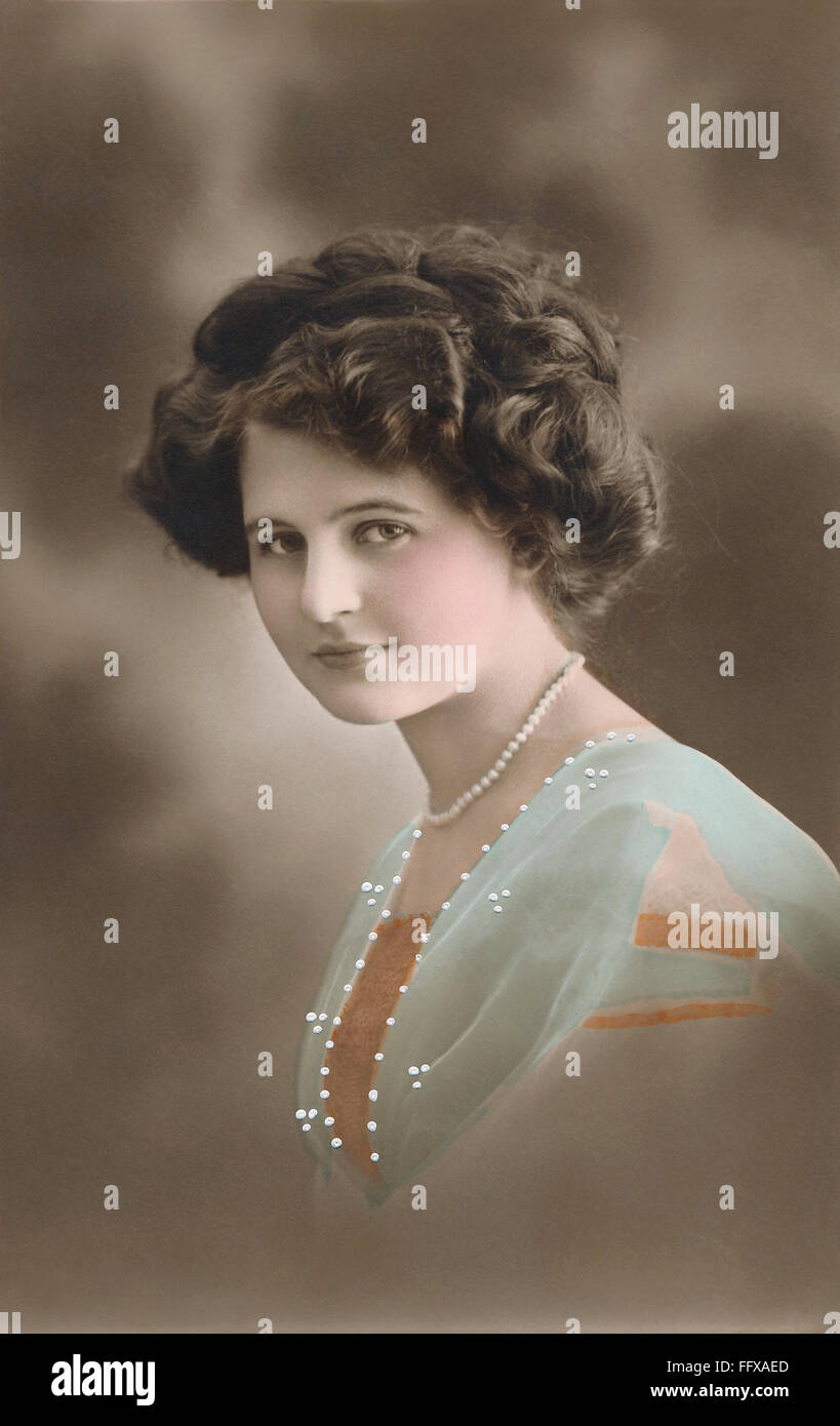 Hand-coloured sepia postcard of a portrait of a beautiful Edwardian woman. Stock Photo