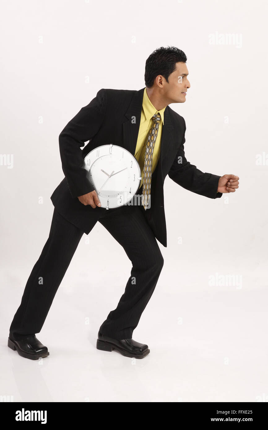 Businessman Profile Pose Holding Wall Clock With One Hand Next His Right Side Of Waist And Running Mr 703t Stock Photo Alamy