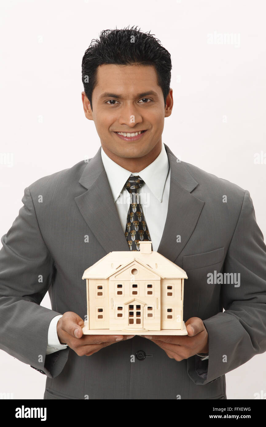 Businessman holding house model in both hand MR#703T Stock Photo - Alamy