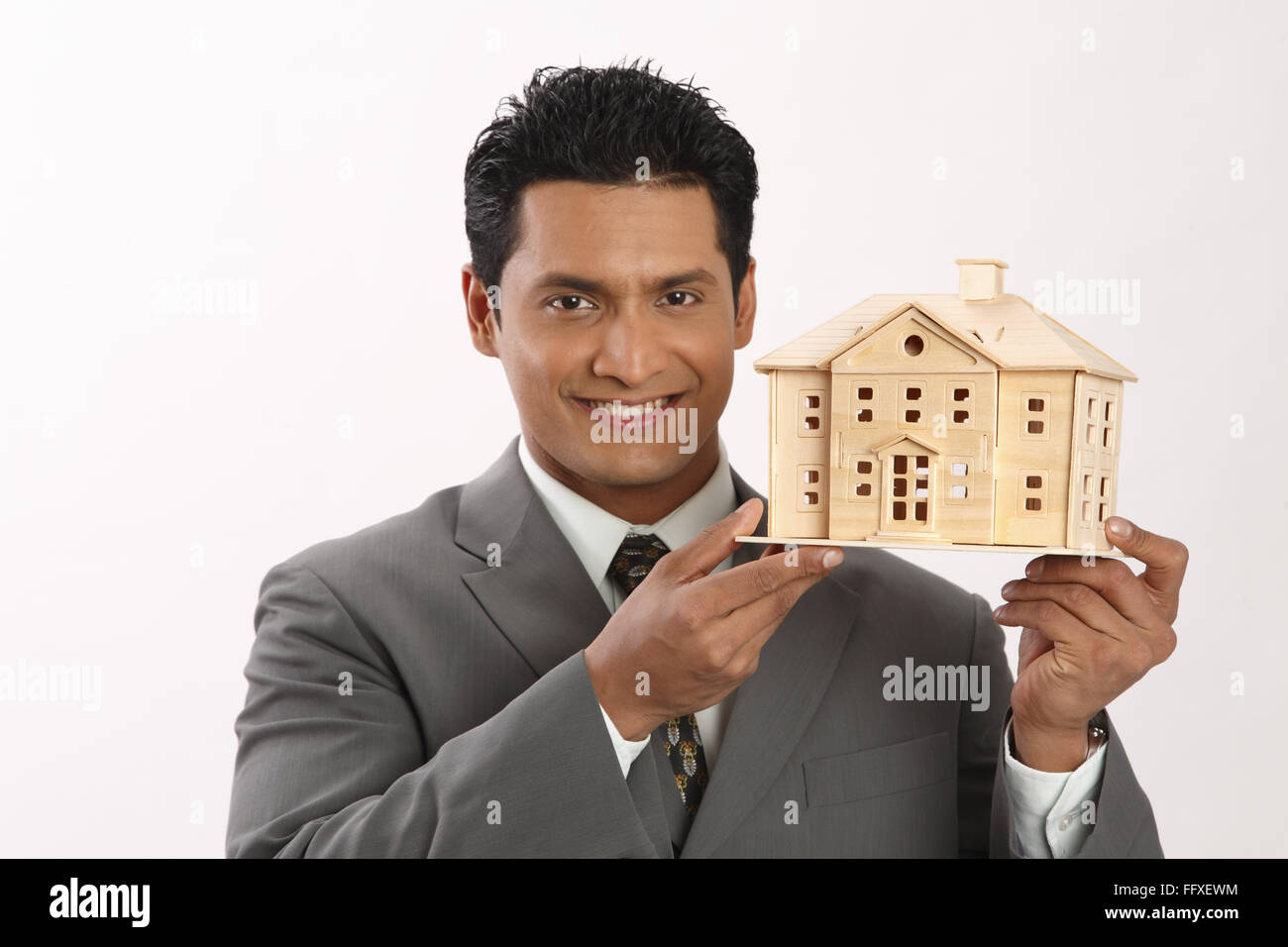 Businessman holding house model in both hand MR#703T Stock Photo - Alamy