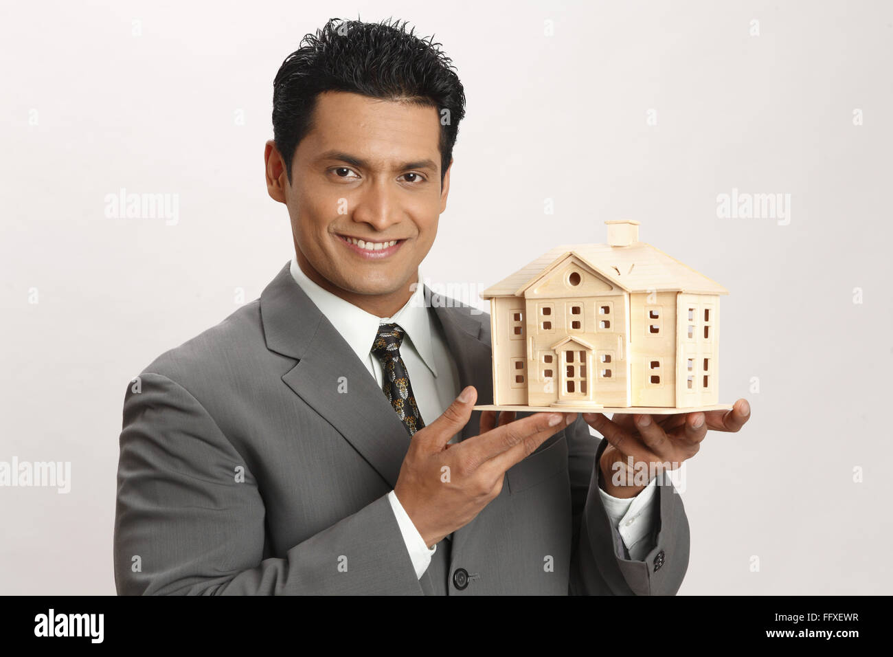 Businessman holding house model in both hand MR#703T Stock Photo - Alamy