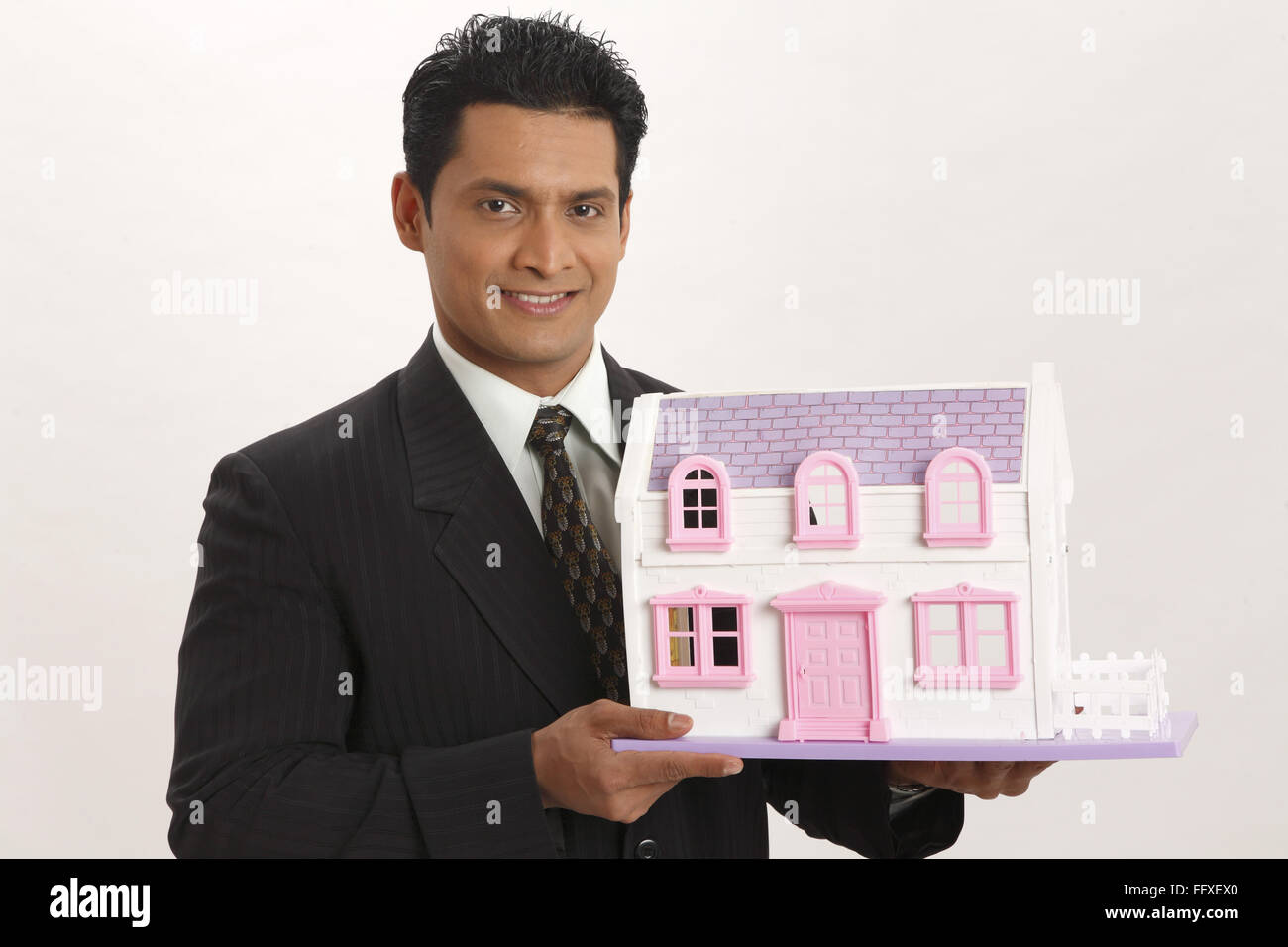 Businessman holding house model in both hand MR#703T Stock Photo - Alamy