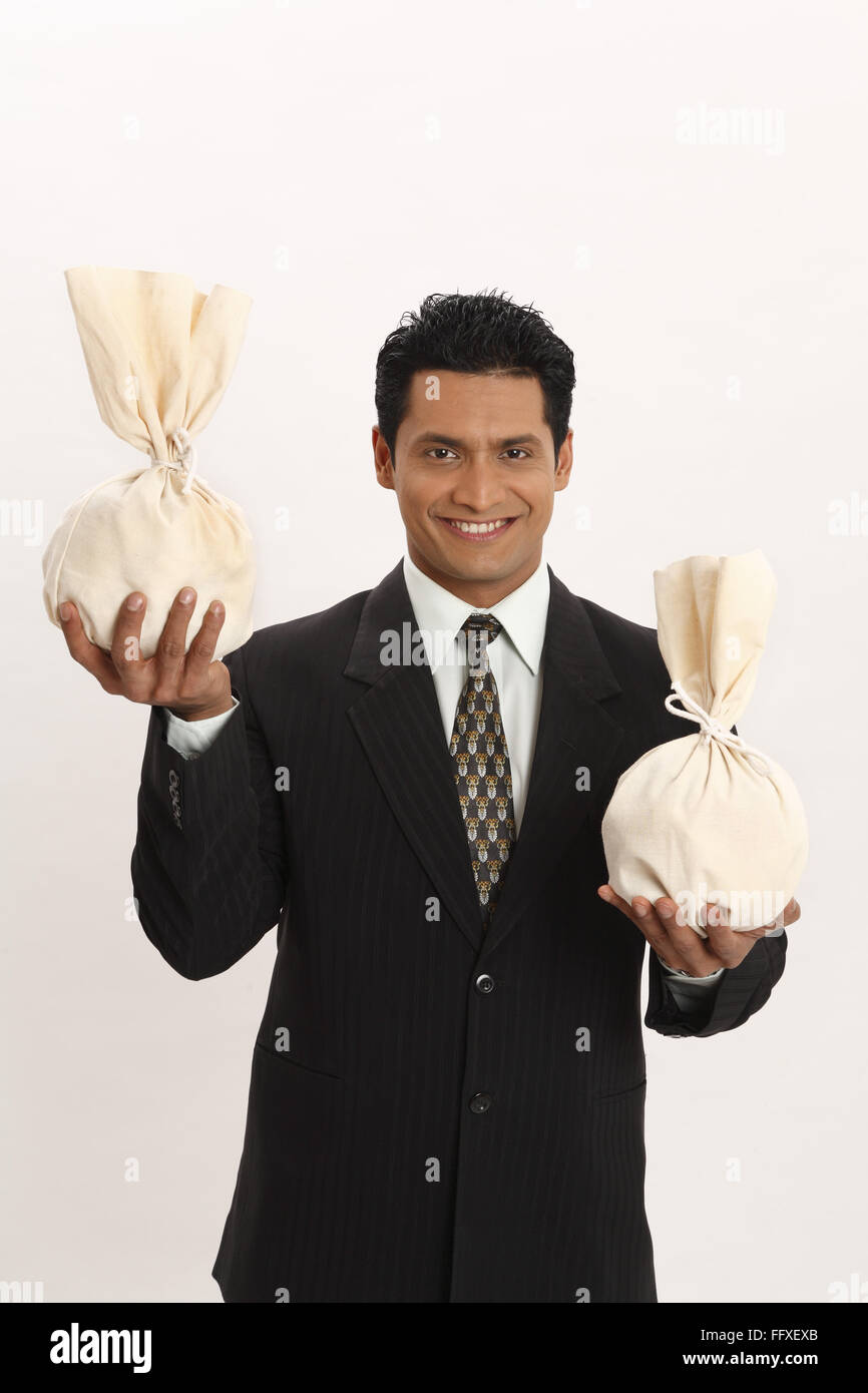 Businessman holding money bags in both hands MR703T Stock Photo Alamy