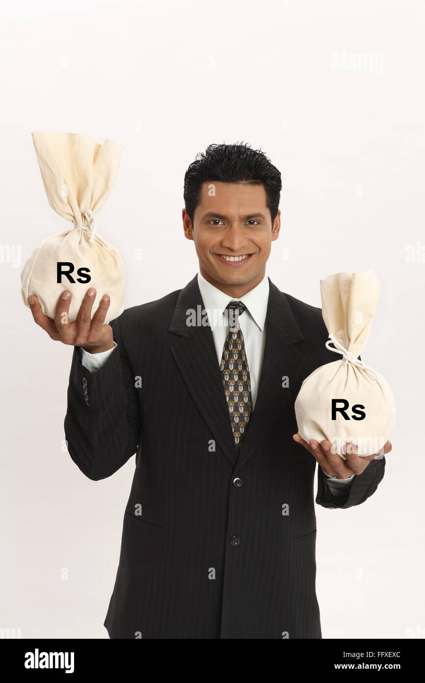 Businessman holding money bags in both hands MR703T Stock Photo Alamy
