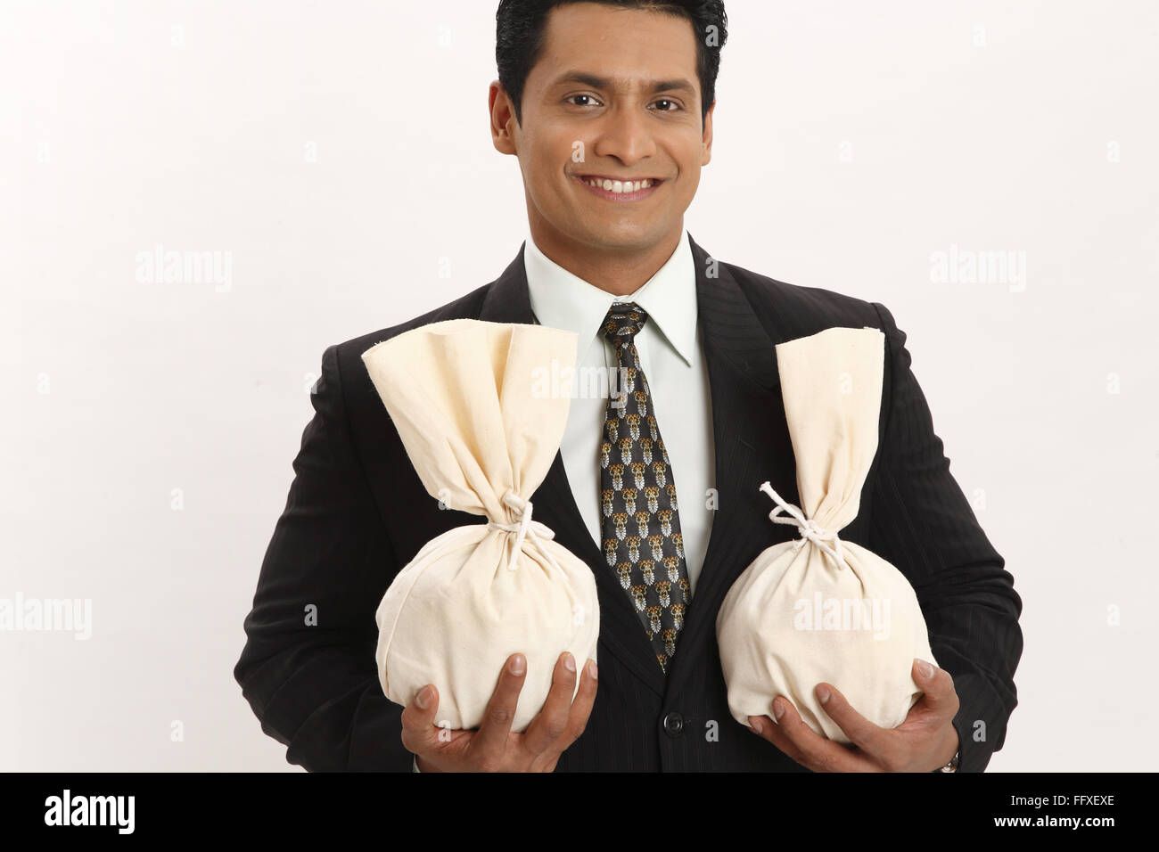 Businessman holding money bags in both hands MR#703T Stock Photo - Alamy