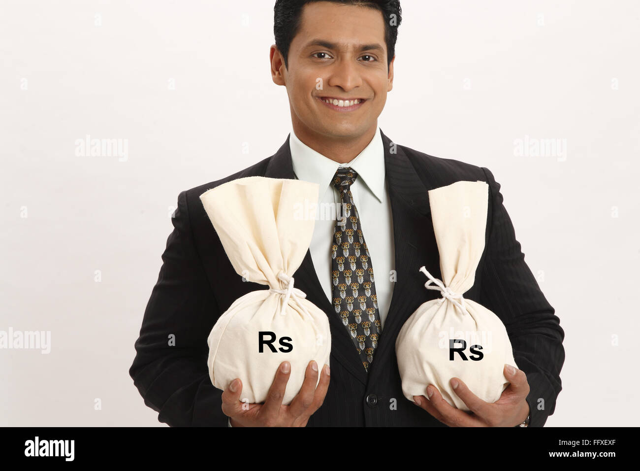 Businessman holding money bags in both hands MR#703T Stock Photo - Alamy