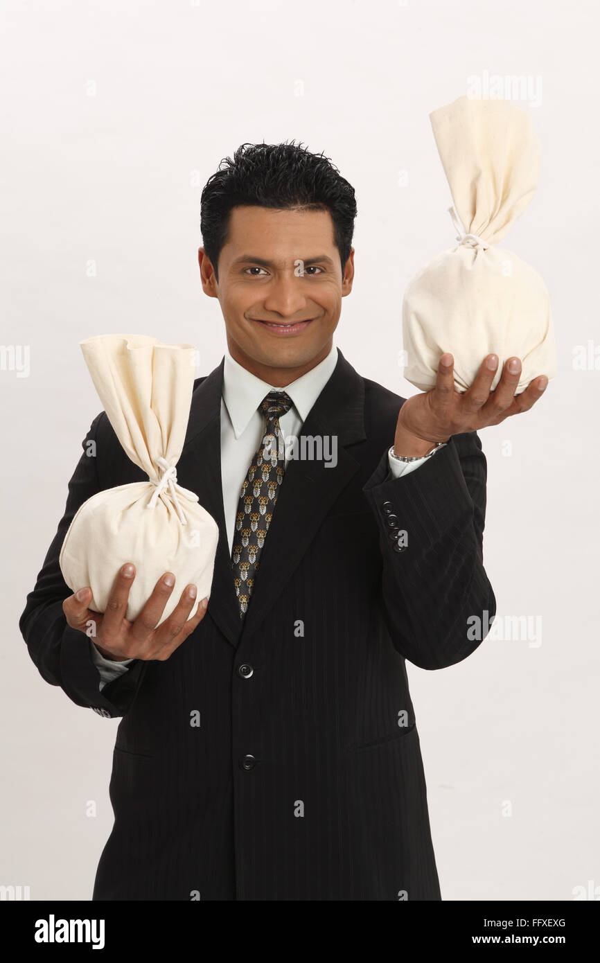 Businessman holding money bags in both hands MR#703T Stock Photo - Alamy
