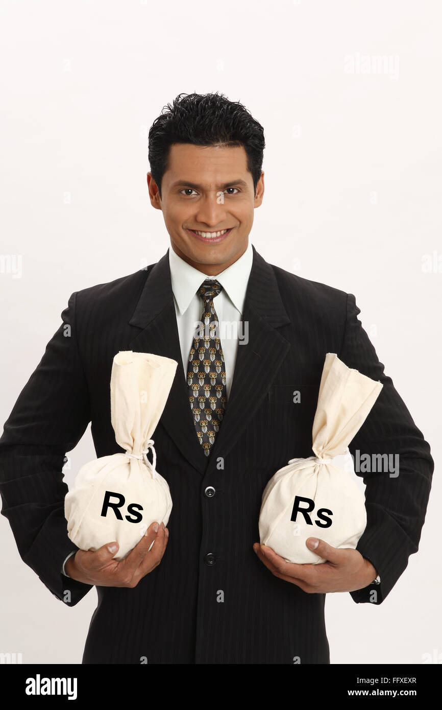 Businessman holding money bags in both hands MR703T Stock Photo Alamy