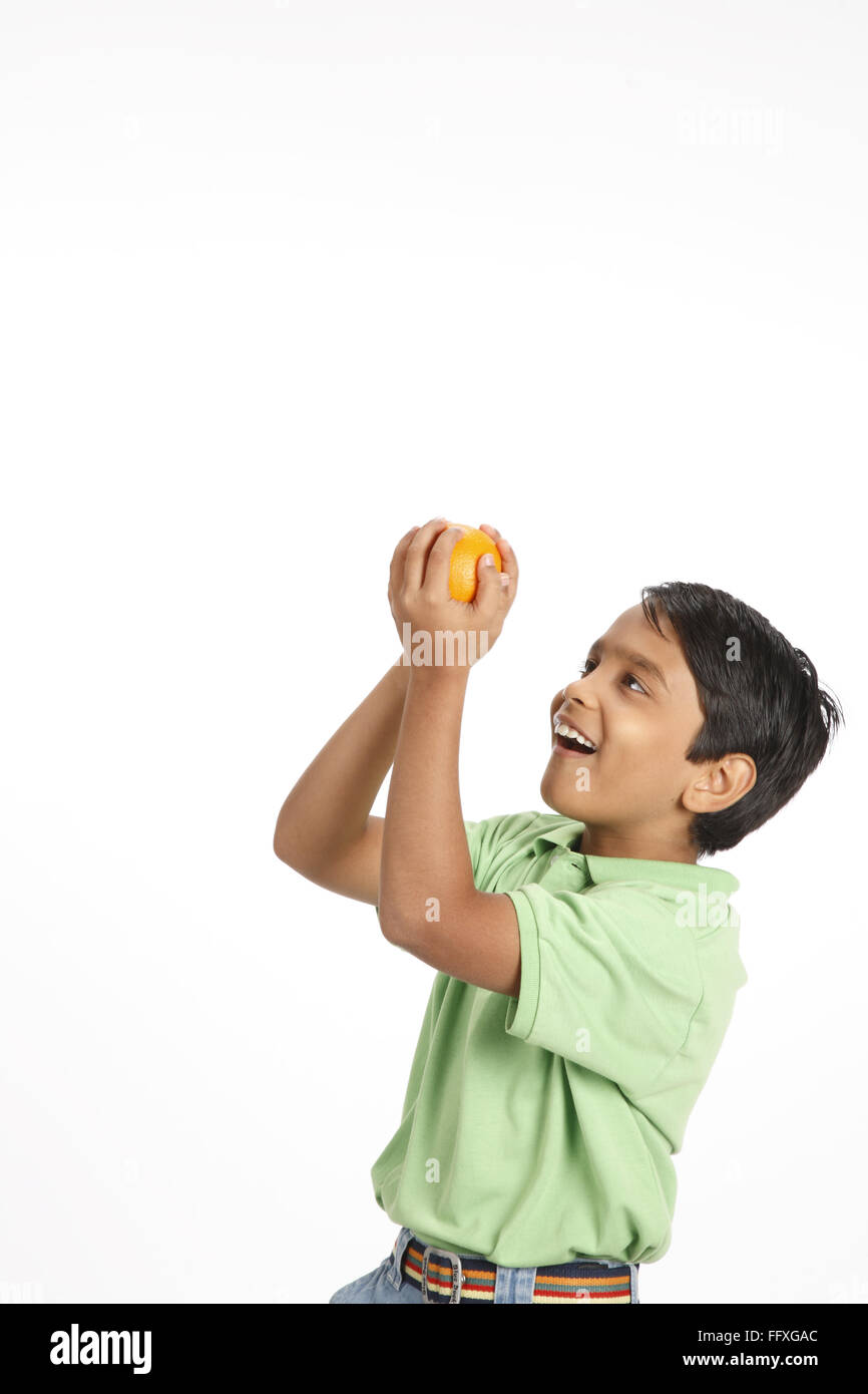 Ten year old boy taken catch of orange in both hands MR#703V Stock Photo