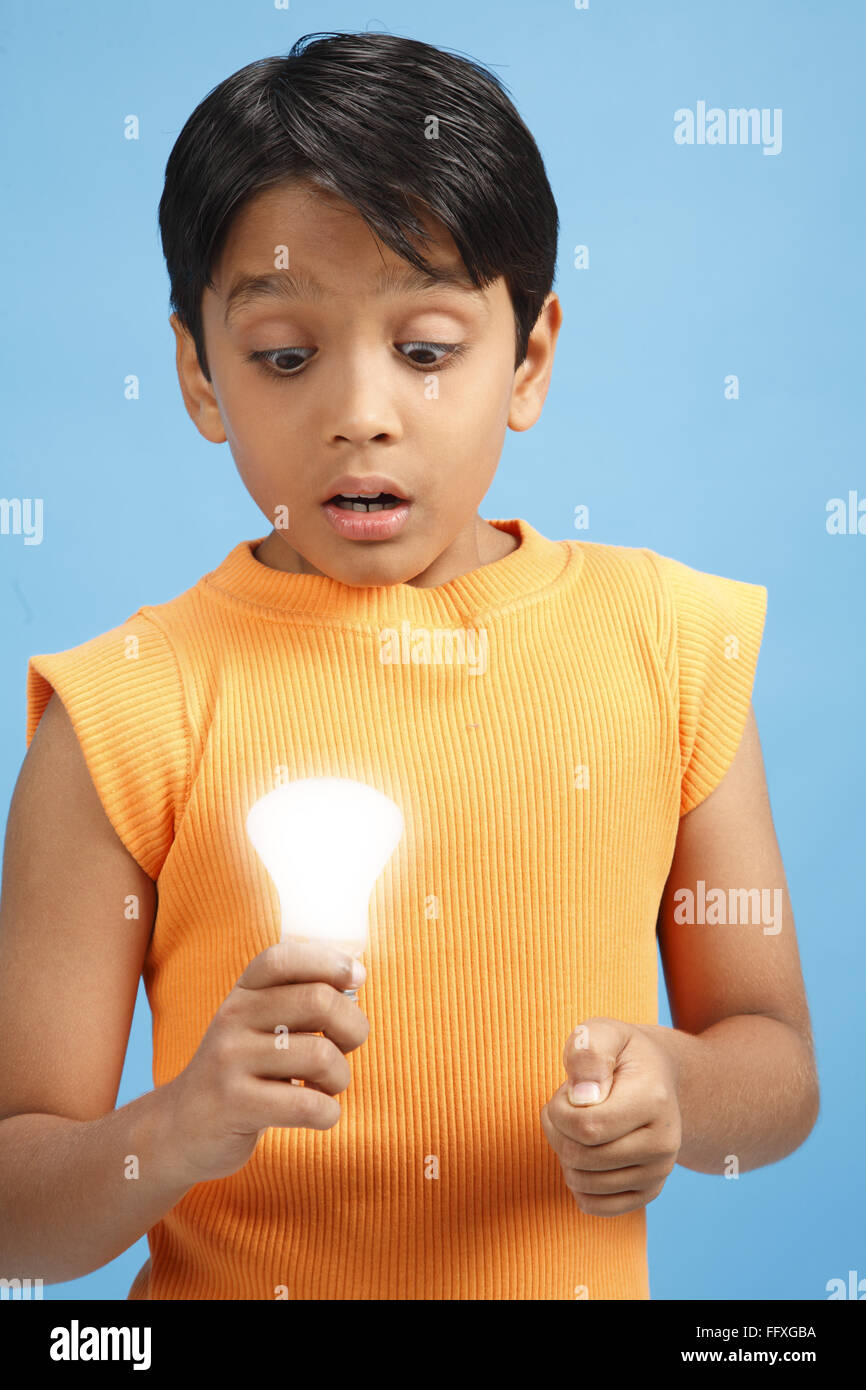 Ten year old boy holding illuminated electric bulb in his hand MR#703V Stock Photo