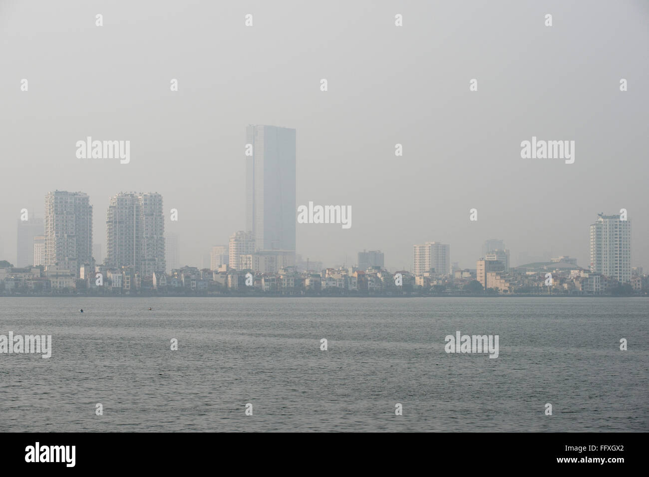 Mist, fog or smog pollution in a hazy skyline of Hanoi viewed over Westlake, Vietnam, January Stock Photo