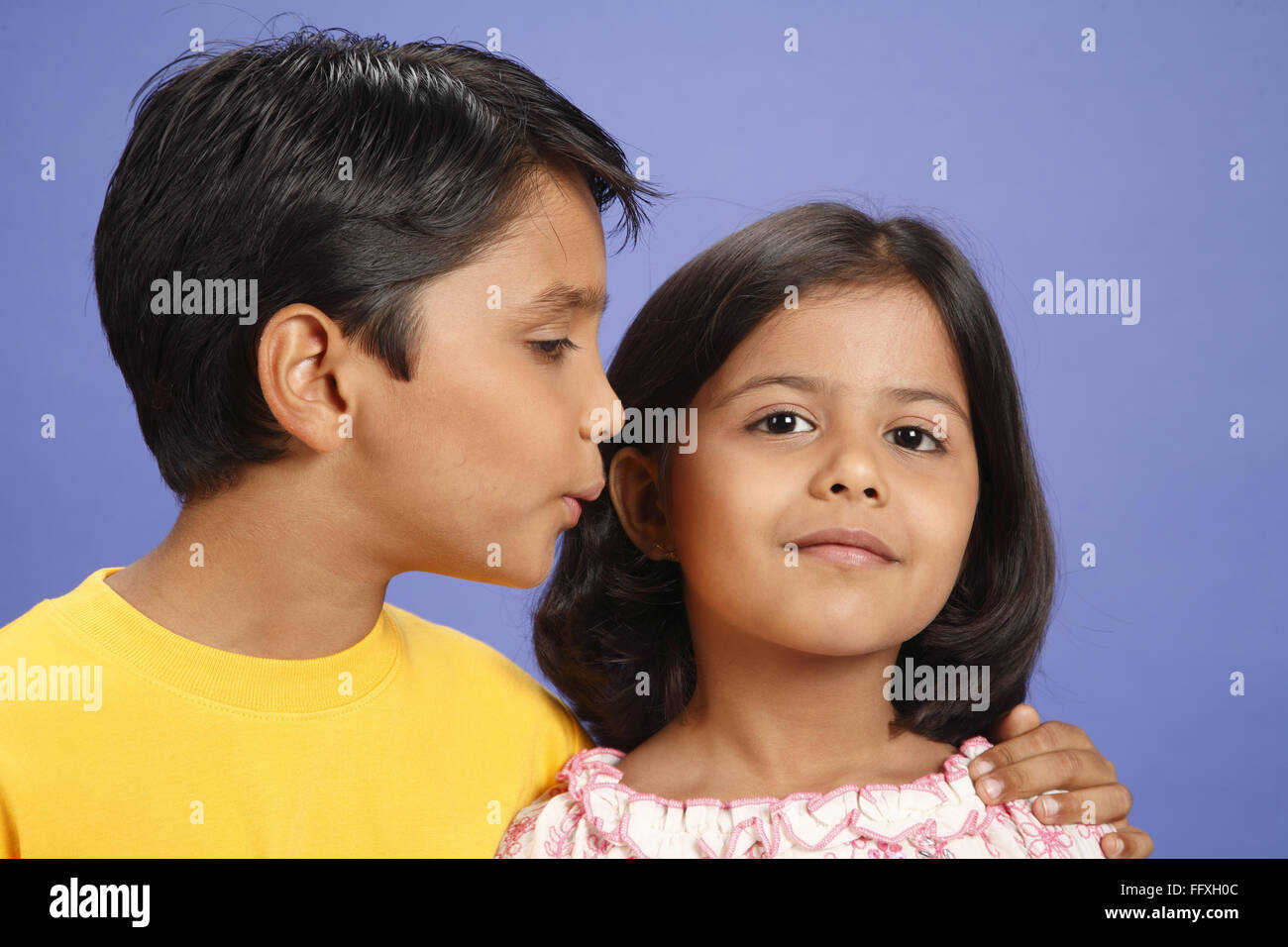 Ten year old boy kissing eight year old girl's cheek MR#703U,703V Stock Photo
