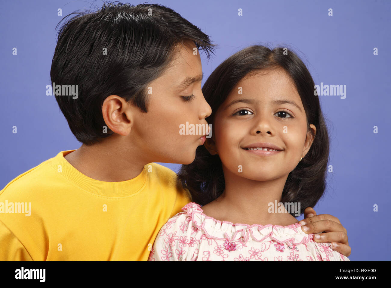 Ten year old boy kissing eight year old girl's cheek MR#703U,703V Stock Photo